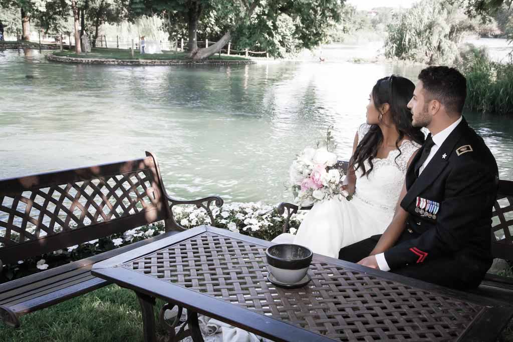 sposi seduti osservano il fiume mincio